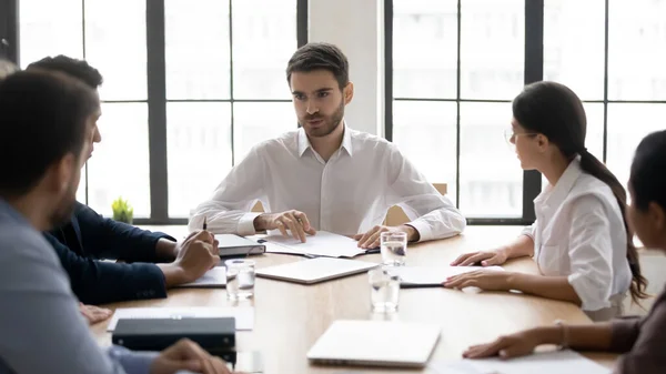 Millennial mannelijke mentor instrueren gemengde ras teamgenoten op het werk. — Stockfoto