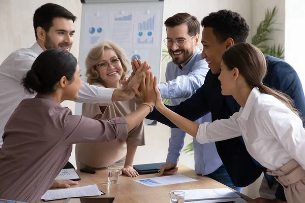 Feliz grupo internacional uniendo sus manos en alto gesto de cinco. — Foto de Stock