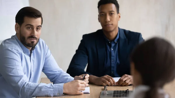 Gericht jong gemengd ras teamgenoten luisteren naar collega in het kantoor. — Stockfoto