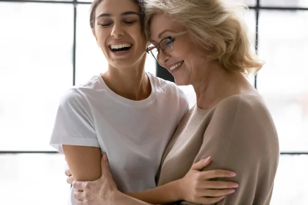 Feliz familia de diferentes generaciones femeninas riéndose en casa. — Foto de Stock