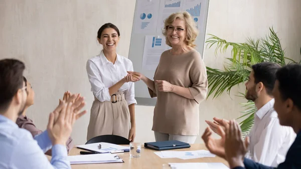 Sonriente líder de los años 60 estrechando la mano con feliz joven colega árabe. — Foto de Stock