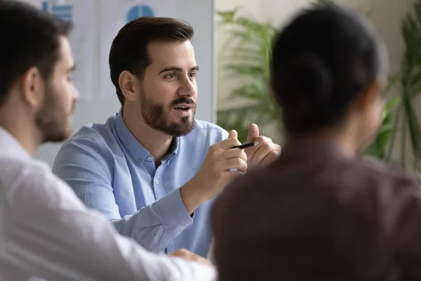 Happy young businessman discussing project with colleagues. — Stock Photo, Image