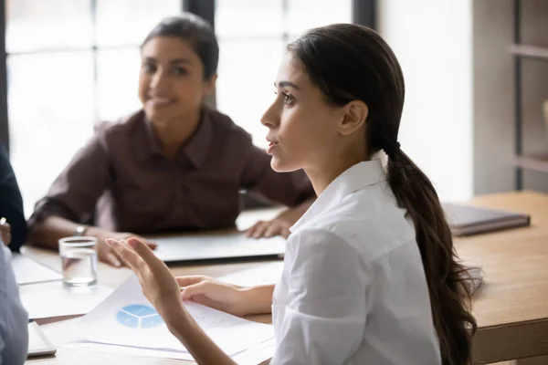 Mujer árabe joven enfocada hablando con diversos compañeros de equipo. — Foto de Stock