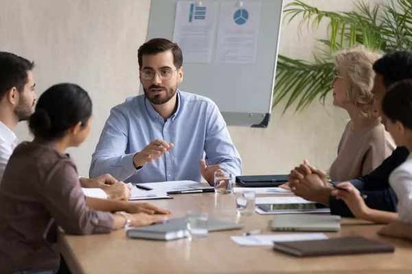 Joven empresario centrado en mantener una reunión de lluvia de ideas con sus colegas. — Foto de Stock