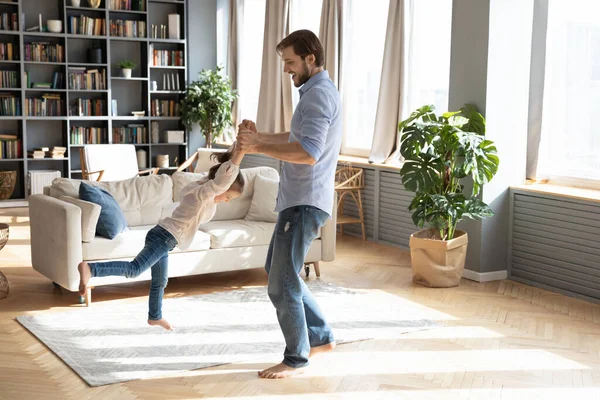 Playful young father swaying baby girl in air. — Stock Photo, Image