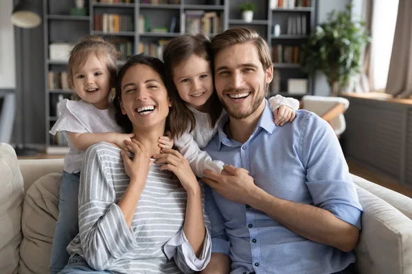 Retrato de niños pequeños cariñosos abrazando a padres jóvenes felices. — Foto de Stock