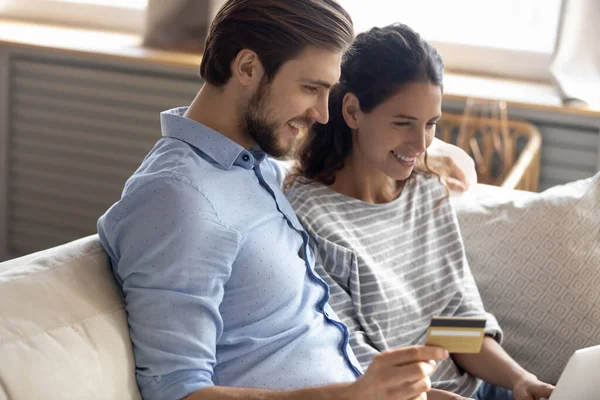 Feliz jovem casal familiar envolvido em compras na internet em casa. — Fotografia de Stock