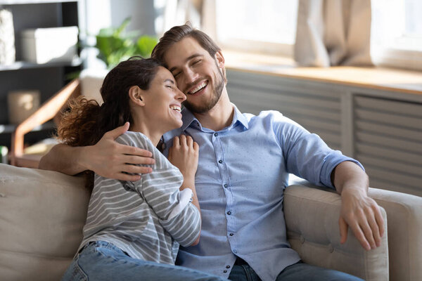 Эмоционально позитивная романтическая семейная пара смеется над смешной шуткой.