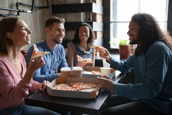 Överlycklig olika vänner njuter av pizza i caféet tillsammans — Stockfoto