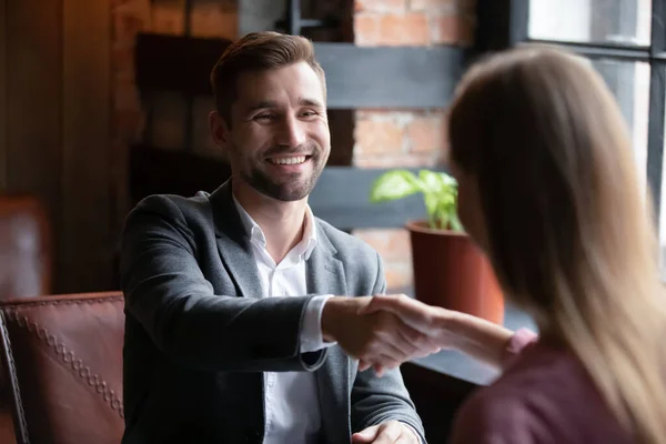 Smiling man executive greeting candidate on job interview in cafe