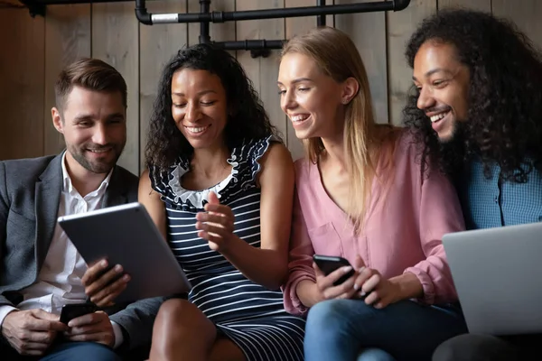 Heureux diverses personnes qui s'amusent avec des gadgets ensemble, bavarder — Photo