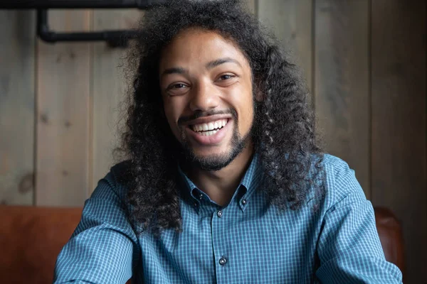 Afro-Amerikalı gülümseyen bir adam video çağrısı yapıyor.