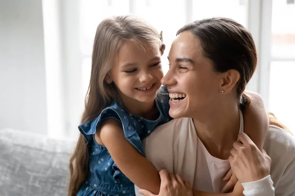 Happy small kid girl cuddling laughing beautiful biracial mother. — Stock Photo, Image