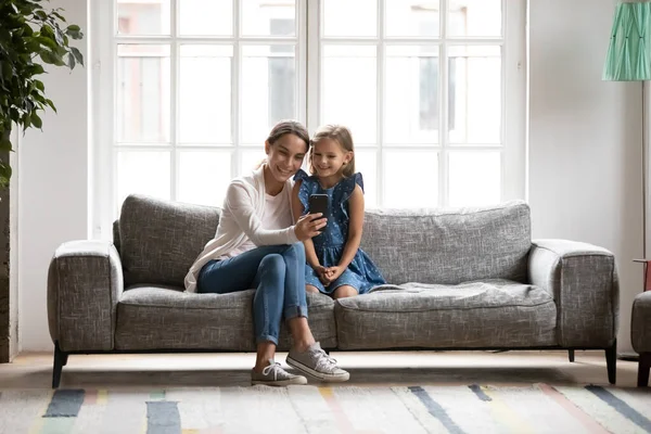 Mosolygó fiatal biracial nő pózol szelfi a lányával. — Stock Fotó