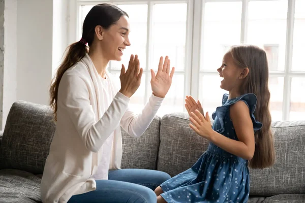 Joven mujer de raza mixta jugando pastel de empanada juego con el niño. — Foto de Stock