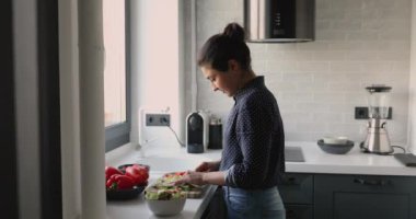 Hintli kadın mutfakta sebze salatası hazırlıyor.