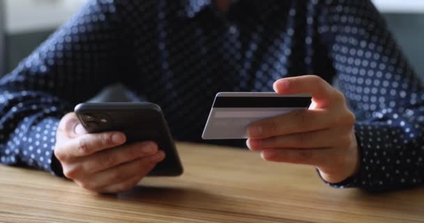 La celebración femenina de la tarjeta de crédito y el teléfono inteligente hace el pago instantáneo primer plano — Vídeos de Stock