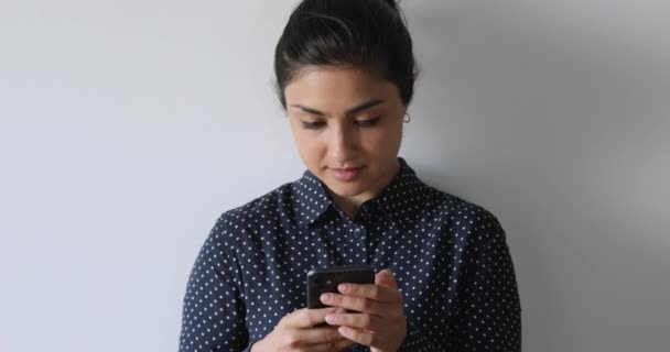 Sorrindo indiano feminino segurando smartphone conversando com amigo online — Vídeo de Stock
