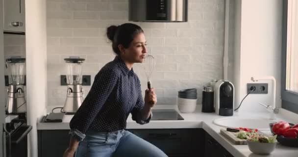 Indisk kvinnlig dans sjunger sång medan matlagning i köket — Stockvideo