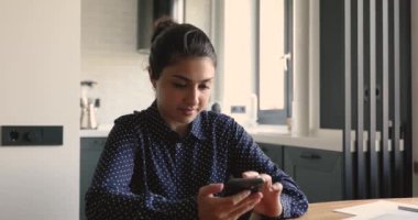 Hintli kadın akıllı telefon tutuyor SMS okuyor, sosyal ağlarda sohbet ediyor