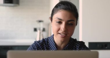 Hintli kadın iş arkadaşıyla video konferans uygulaması ve dizüstü bilgisayar kullanarak konuşuyor