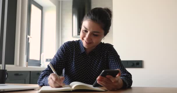 Femme utilisation d'Internet trouver des informations utiles écrit dans copybook — Video