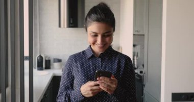 Evde elinde akıllı telefon tutan kadın mutlu bir mesaj aldı.