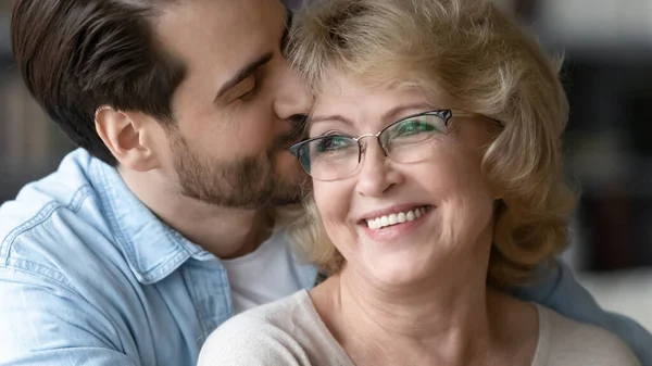 Nahaufnahme erwachsener Sohn küsst schöne reife Mutter mit Brille — Stockfoto