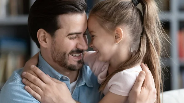 Закройте улыбающиеся отец и маленькая дочь наслаждаясь нежным моментом — стоковое фото