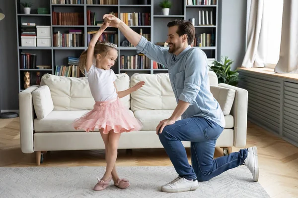 Loving father standing on knee, holding adorable little daughter hand — Stock Photo, Image