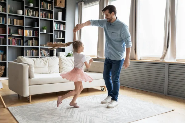 Liefdevolle jonge vader houdt dochter hand, dansen in de woonkamer — Stockfoto