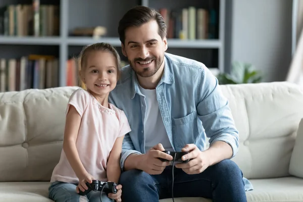 Feliz padre e hija pequeña jugando videojuegos en casa —  Fotos de Stock