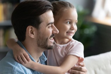 Hayalperest genç baba ve küçük kızın kucaklaşması.