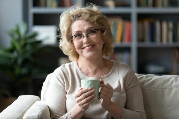 Cabeza retrato sonriente mujer madura sosteniendo taza de té —  Fotos de Stock