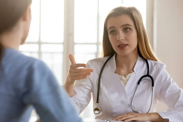 Allvarlig kvinnlig läkare konsultera patienten vid läkarbesök på sjukhus — Stockfoto