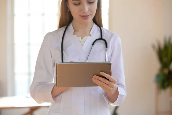 Close-up gefocuste jonge vrouw arts met behulp van computer tablet — Stockfoto