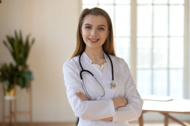 Beyaz üniforma giyen gülümseyen genç kadın portresi.