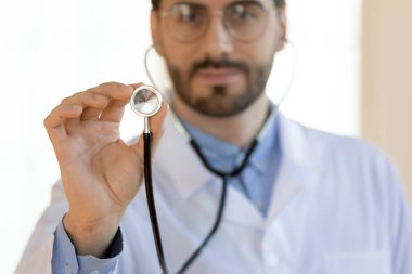 Steteskop tutan ciddi genç bir doktor, tıbbi kontrol konsepti.