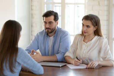 İş görüşmesinde adayları dinleyen iki kendine güvenen insan kaynakları yöneticisi