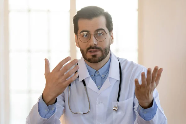 Hlava snímek portrét mladý lékař nosí brýle mluvení, konzultace on-line — Stock fotografie