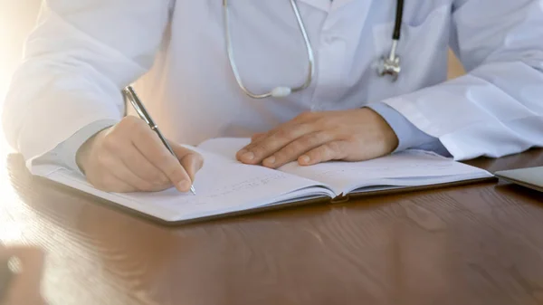 Close up doctor writing in patient card, working with documents — Stock Photo, Image