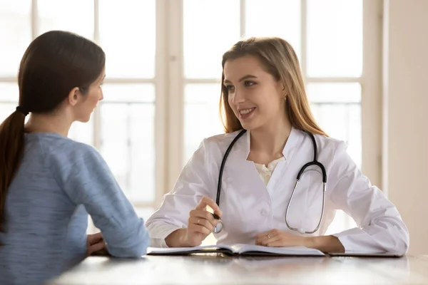 Leende kvinnlig läkare terapeut konsultera patienten vid medicinska besök — Stockfoto