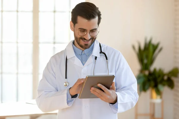 Lächelnder Arzt mit Brille und Tablet im Büro — Stockfoto