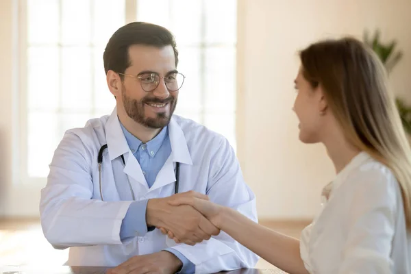 Közelkép mosolygós orvos rázza türelmes kezét a találkozón — Stock Fotó