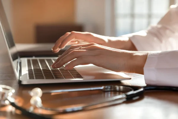 Primer plano médico mujer que trabaja en el ordenador portátil, escribiendo en el teclado —  Fotos de Stock