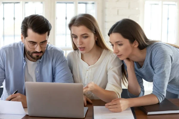 Trois collègues travaillant ensemble sur le projet, regardant l'écran d'ordinateur portable — Photo