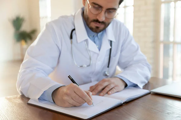 Fokussierter Arzt in Uniform, der mit Dokumenten arbeitet — Stockfoto