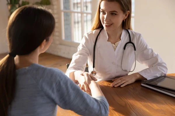 Leende kvinnlig läkare terapeut skakar patientens hand vid mötet — Stockfoto