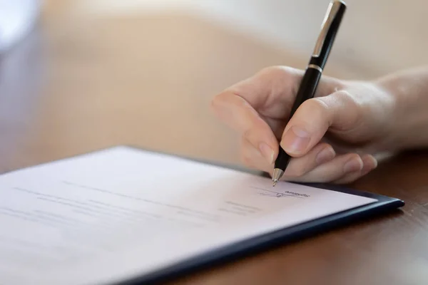 Cierre mujer sosteniendo pluma, firmando documento, haciendo trato — Foto de Stock