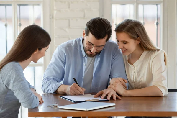 Happy young married couple signing contract, making successful deal — Stock Photo, Image